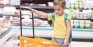 Little boy with big shopping cart in the store