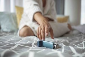 Asmathic girl catching inhaler having an asthma attack