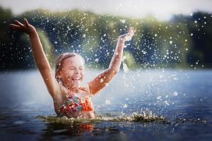 Little,Girl,Smiling,Playing,In,The,River.,A,Girl,With