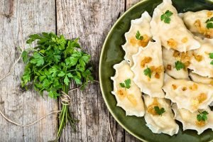 Homemade dumplings with fried onion on plate, top view, cooking concept