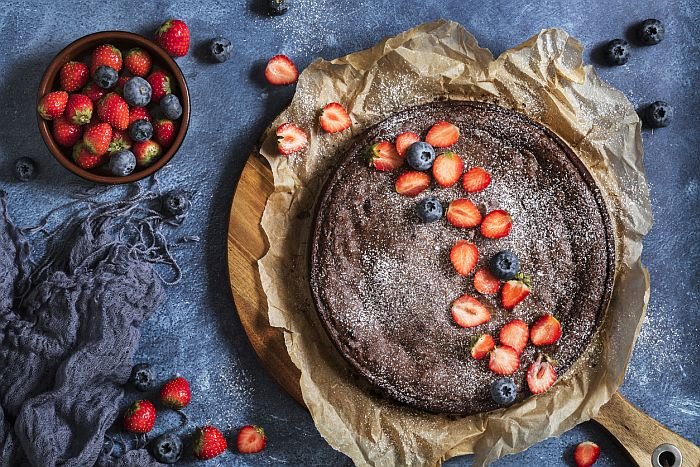 Swedish traditional chocolate cake Kladdkaka with fresh berries, strawberries and blueberries
