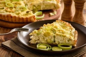 Quiche,With,Leek,And,Cheese,On,Brown,Background.