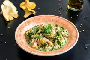 Delicious risotto with chanterelle mushrooms over rustic black background