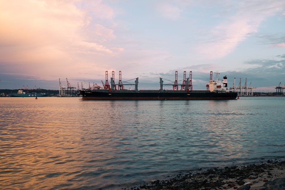 Cargo ship parked at the harbor on a sunny day during sunset